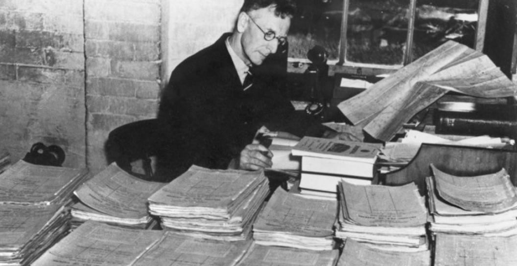 Man at desk covered in files