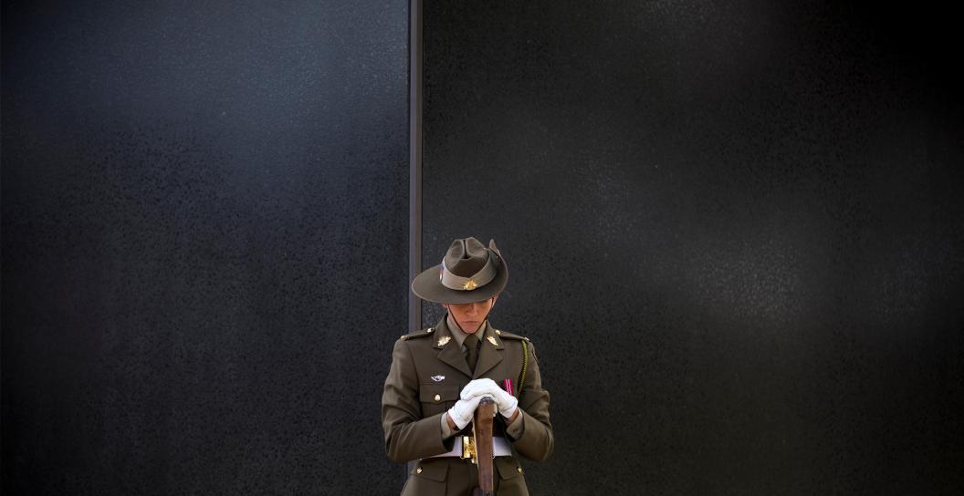Female soldier standing next to Memorial.