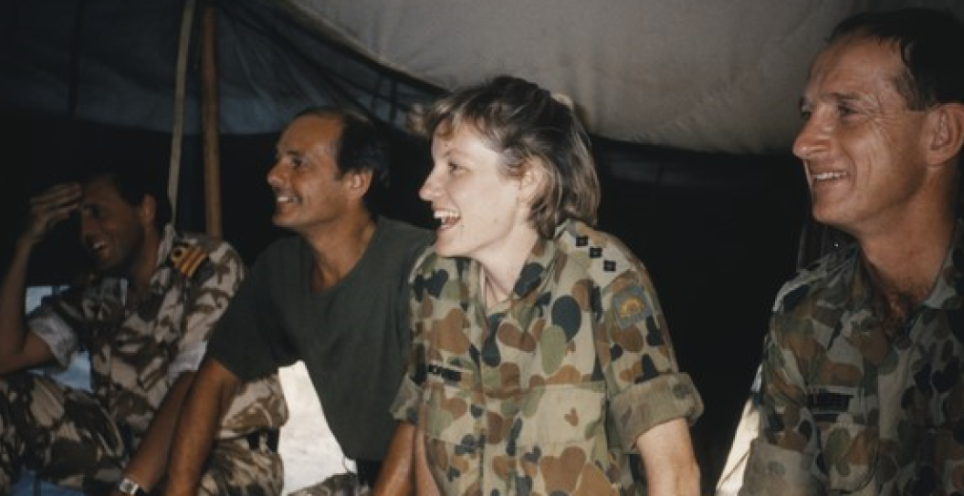 Four people in uniform inside a tent