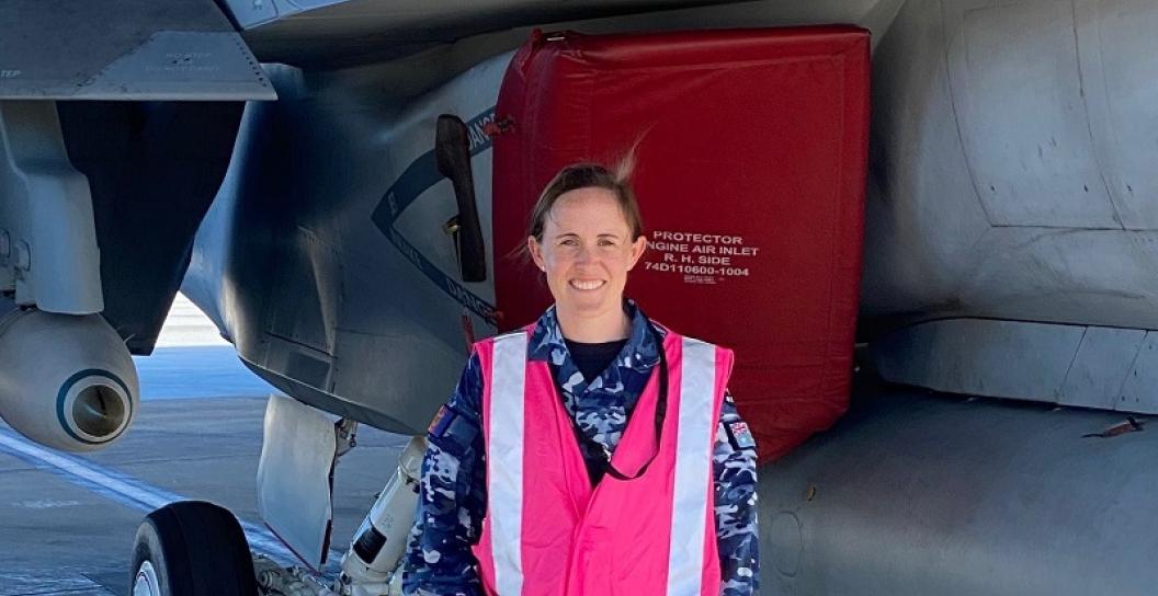 Woman in RAAF uniform standing in front of fighter jet