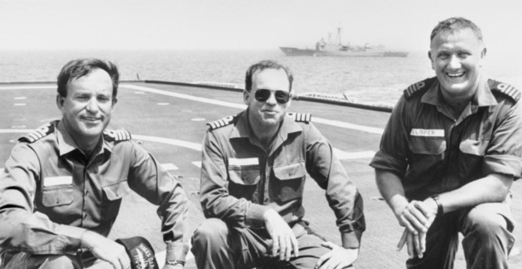 Three men in Navy uniform on deck of warship