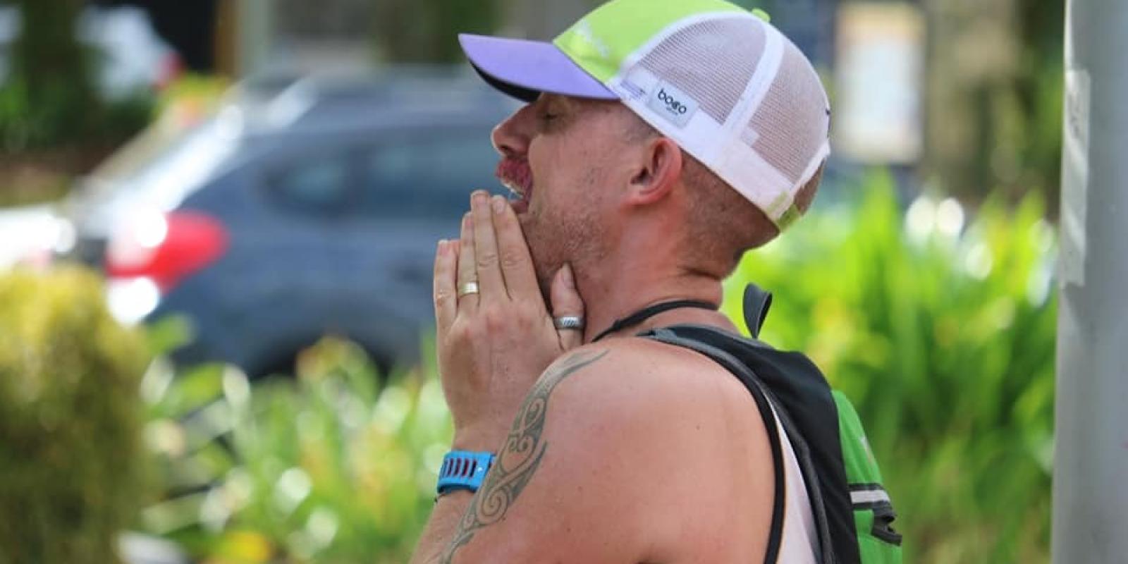 Man in cap with hands on face taking deep breath of relief